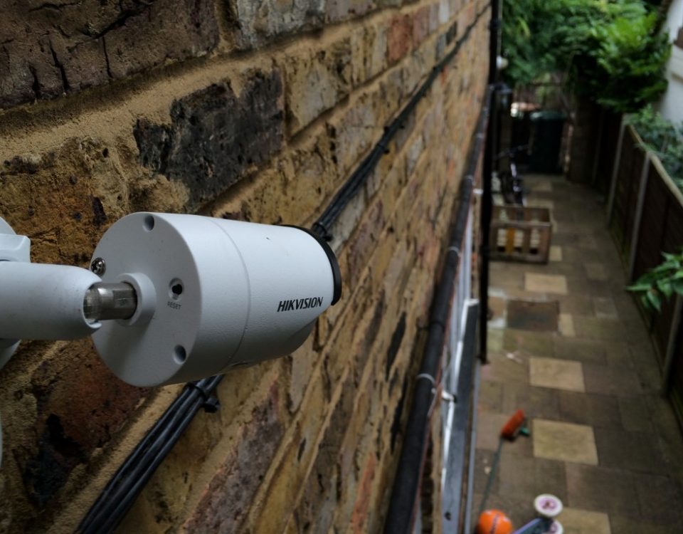 a cctv camera fitted to a house watching alleyway